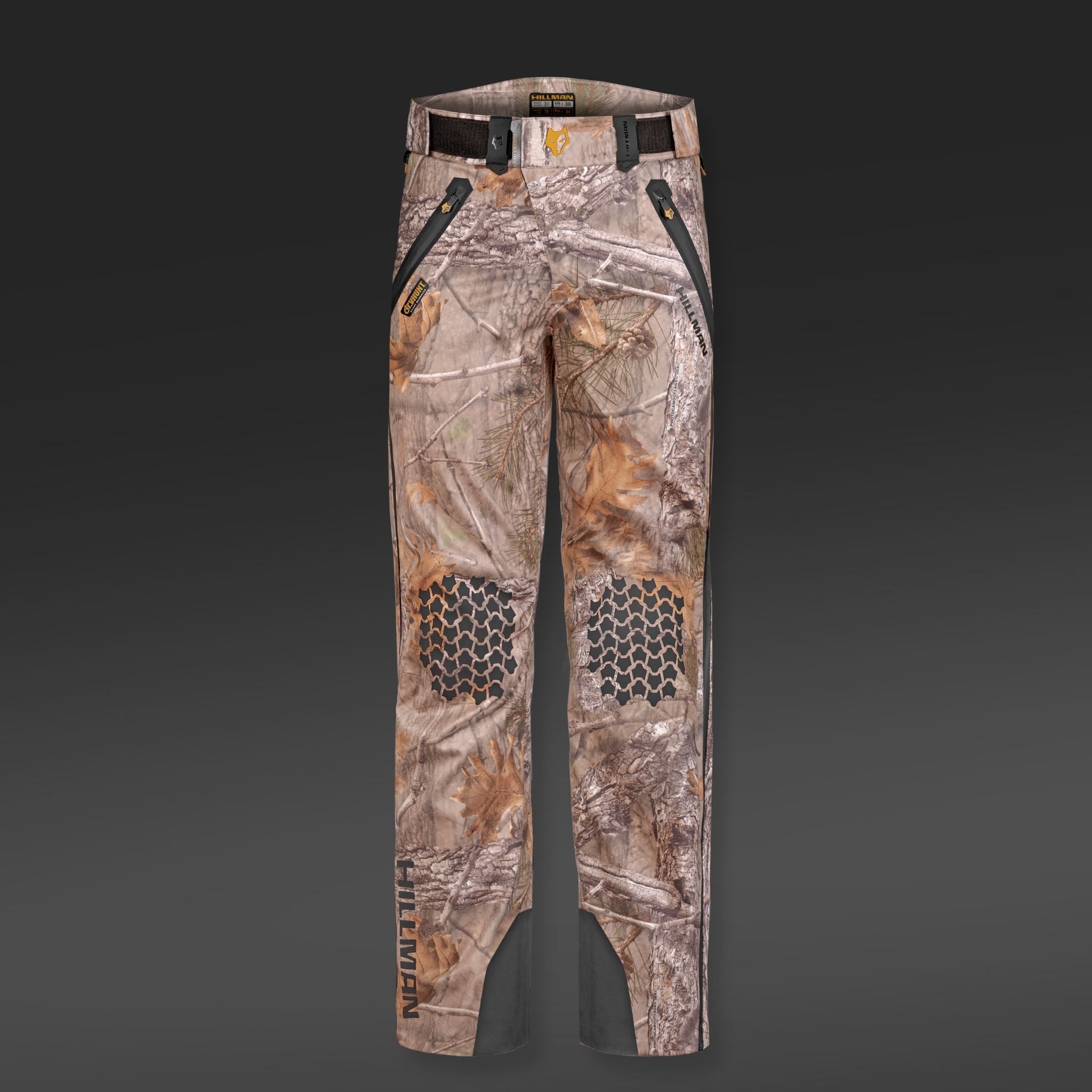 5WL Ultra-Lightweight Waterproof Hunting Trousers by HILLMAN GEAR feature camouflage design with black front pocket zippers, hexagonal knee patterns, and dark accents. Breathable with belt loops and branding on the lower left leg, these pants have a dark-to-light gray background transition.
