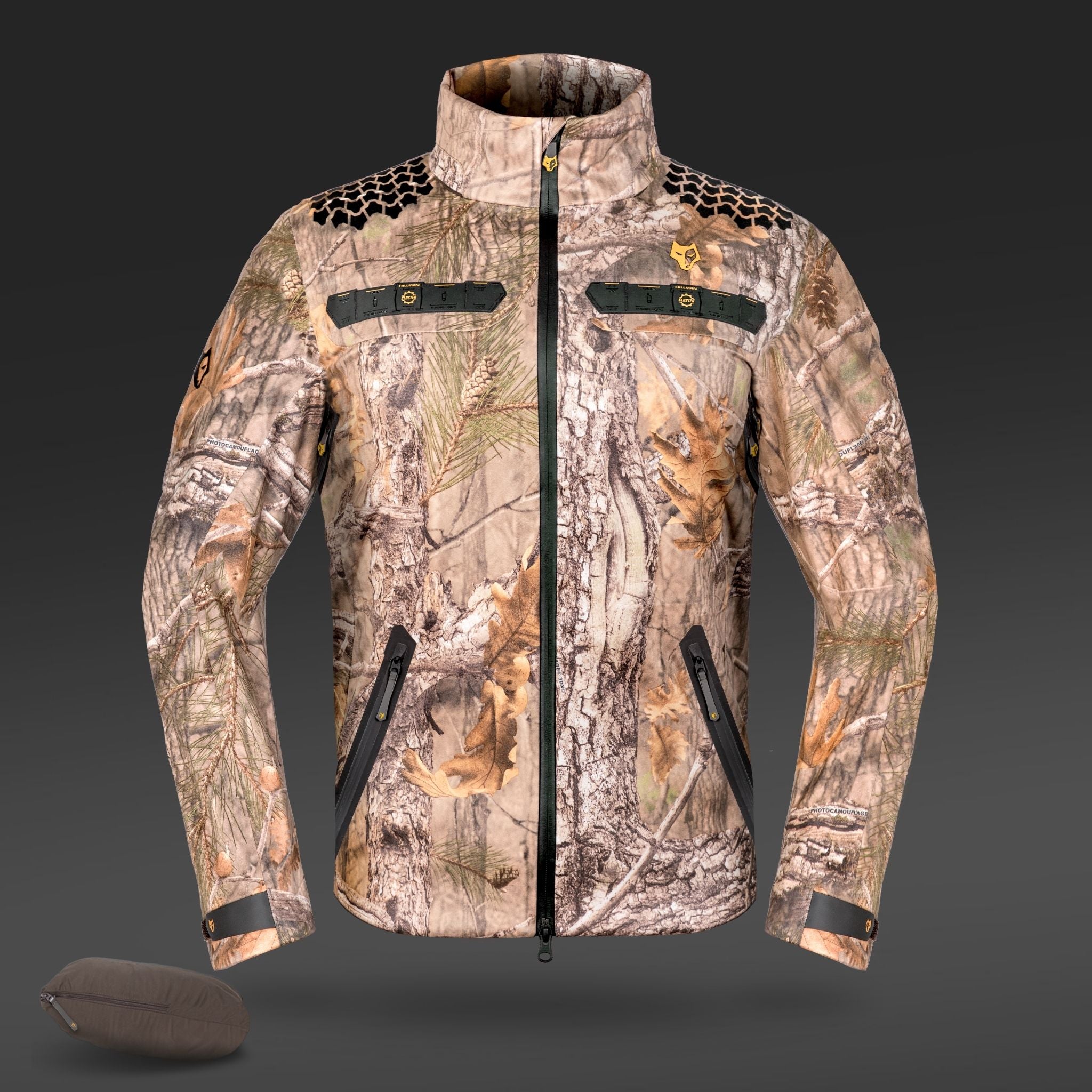 The HILLMAN GEAR ultra-lightweight camo rain jacket, a waterproof camouflage hunting coat with zippered pockets, black accents, and a high collar, is shown on a gray background beside its matching carrying pouch.