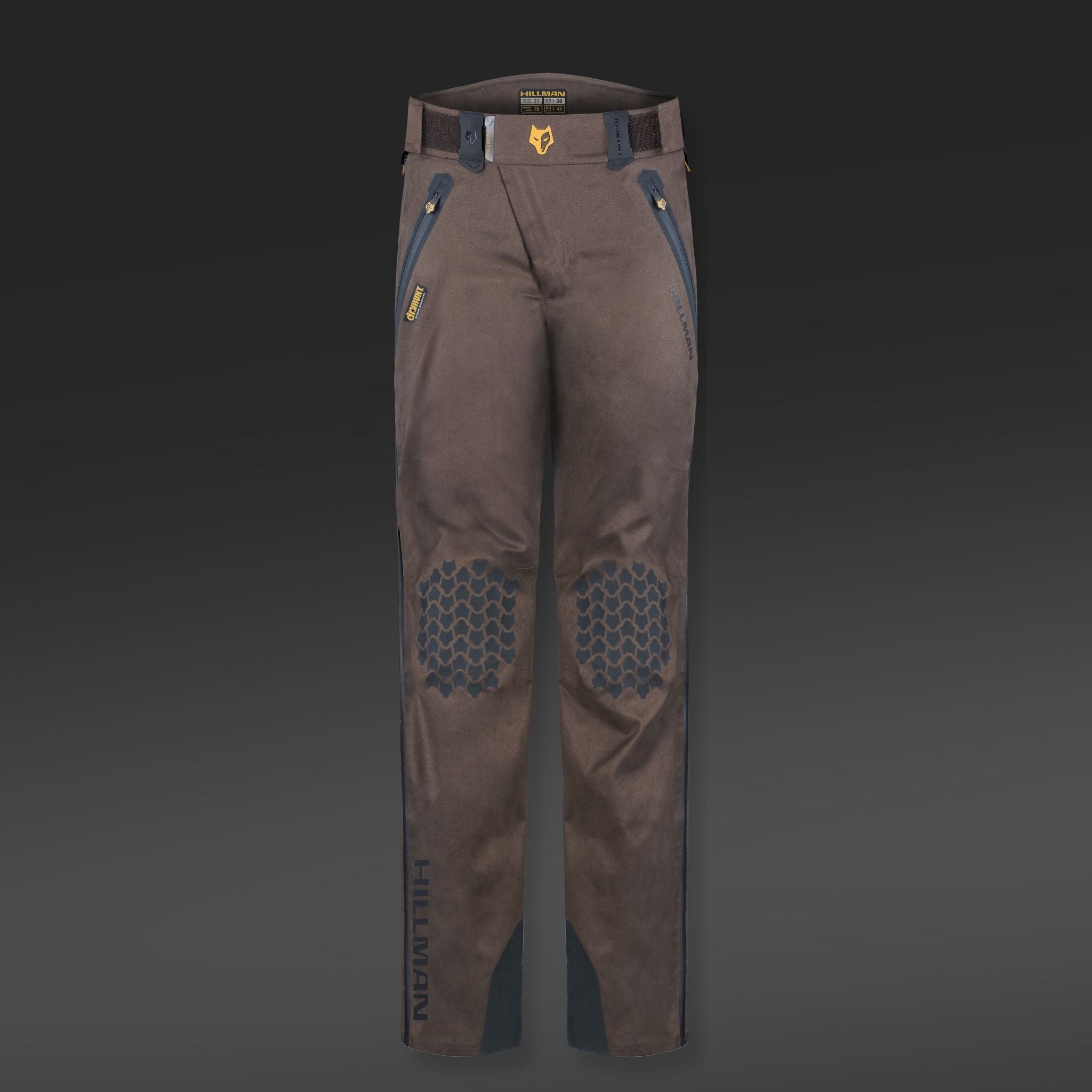 Brown and blue 5WL ultra-lightweight waterproof hunting trousers featuring reinforced knee patches with hexagonal patterns, set against a dark gradient background. The brand name HILLMAN GEAR is printed on the lower leg area.