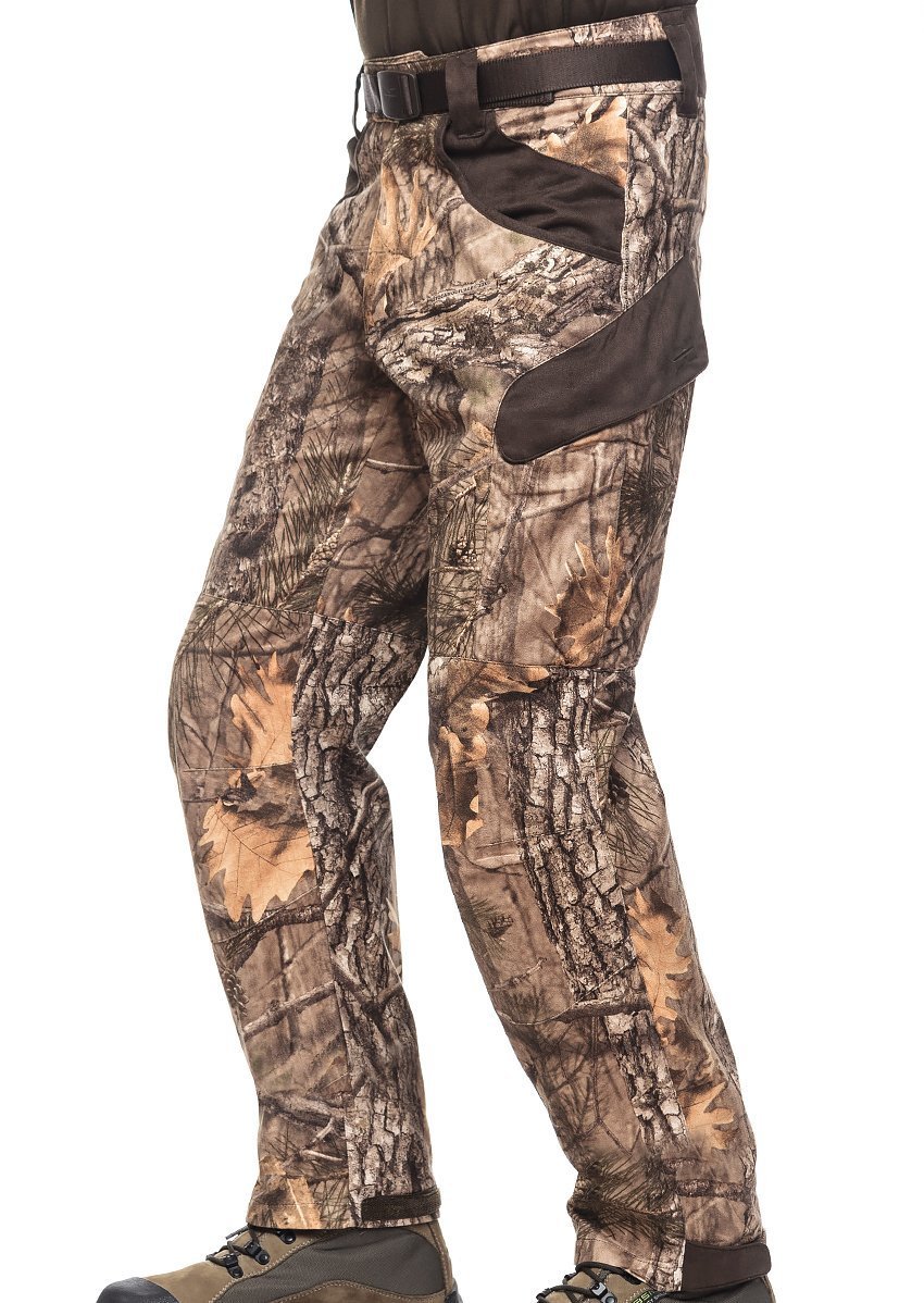 A person wearing Hillman® XPR Silent Hunting Trousers in a tree and leaf camo pattern with brown accents, paired with brown boots and a visible belt.