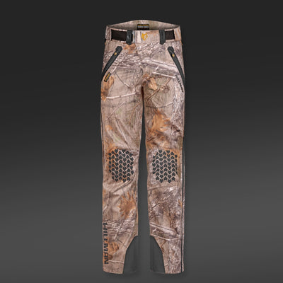5WL Ultra-Lightweight Waterproof Hunting Trousers by HILLMAN GEAR feature camouflage design with black front pocket zippers, hexagonal knee patterns, and dark accents. Breathable with belt loops and branding on the lower left leg, these pants have a dark-to-light gray background transition.