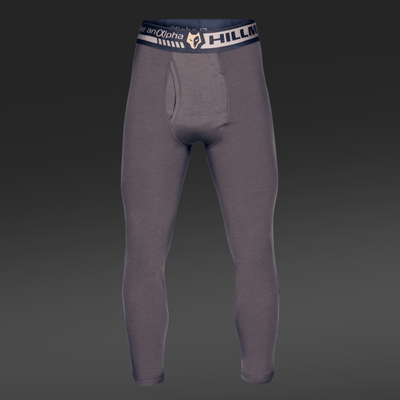 Gray 2BL Thermal Base Layer Trousers by Hillman®GWR, made from merino wool with HILLMAX alpha on the dark waistband and a logo. Displayed against a dark background, these long johns demonstrate their full length and snug fit, perfect as a thermal base layer.